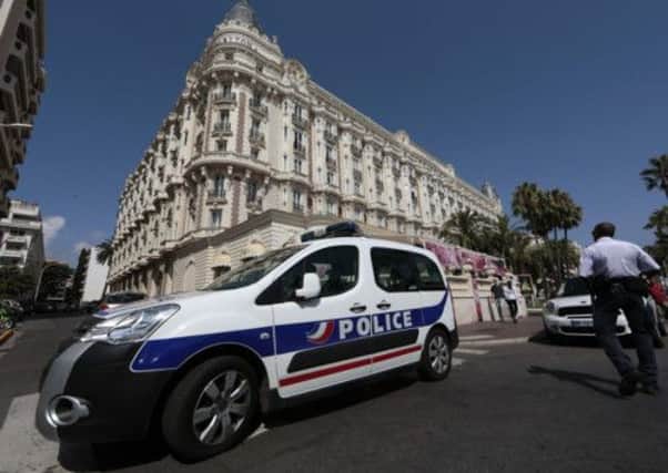 A police car is seen parked outside the Carlton hotel in Cannes, where £34m of jewels and diamonds were stolen. Picture: Reuters