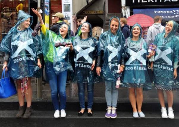 Tourists visiting Edinburgh yesterday refused to be daunted by the rain. Picture: Jane Barlow