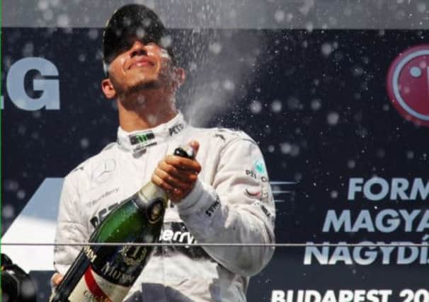 Lewis Hamilton enjoys his champagne moment after an unexpected win in Budapest. Picture: Getty