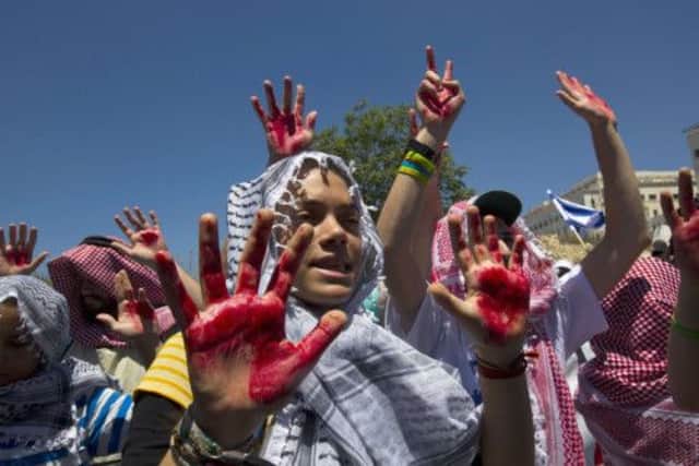 Israelis hold up hands covered in fake blood at a protest in Jerusalem over the release of Palestinian prisoners yesterday. Picture: Reuters