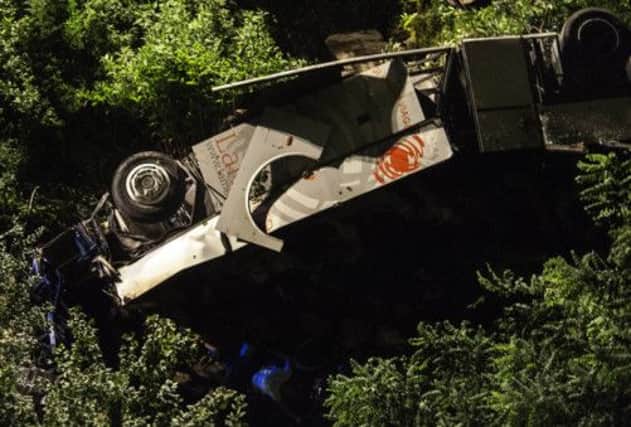 A bus lies on its side after plunging off a highway near Avellino. Picture: AP