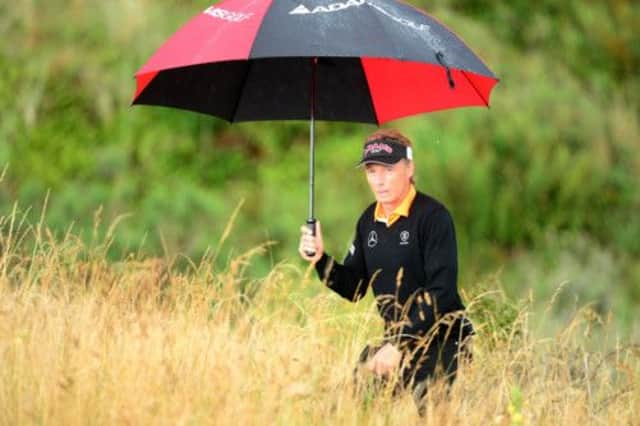 Bernhard Langer takes shelter as heavy rain and lightning interrupt play on the fourth day of the Senior Open Championship. Picture: PA