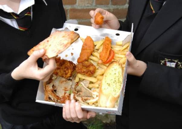 Two children share a (rather unhealthy) lunch. Evoultionary scientists believe that fair, not selfish behaviour, is favoured by evolution. Picture: Robert Perry