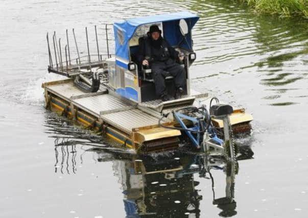 A weed cutter is piloted down the Clyde Canal. Picture: Garry F McHarg