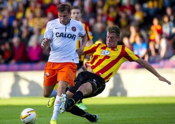 Dundee Utd's David Goodwillie takes on Partick's Aaron Muirhead. Picture: SNS