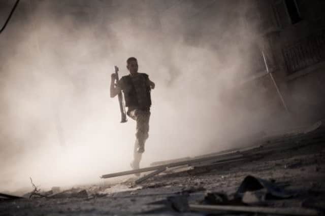 A Free Syrian Army fighter flees after attacking a tank with a rocket-propelled grenade. Picture: AP
