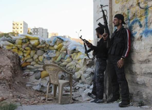 Free Syrian Army fighters take cover behind a wall of sandbags in Ashrafieh, Aleppo. Picture: Reuters