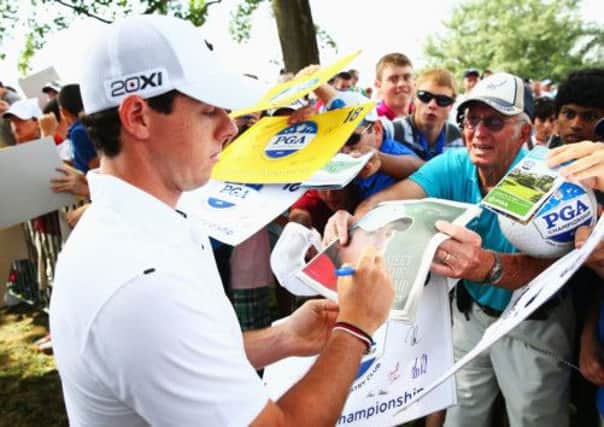 Rory McIlroy signs autographs for fans before going out on a practice round yesterday. Picture: Getty