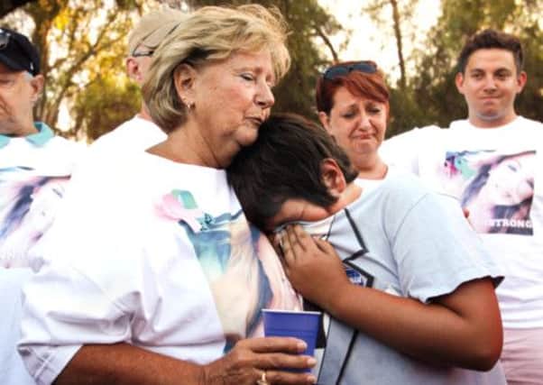 Sara Britt, grandmother of the two siblings, hugs Ethan's best friend Christian 'Boogie'Ingram at a vigil in Lakeside, California. Picture: AP