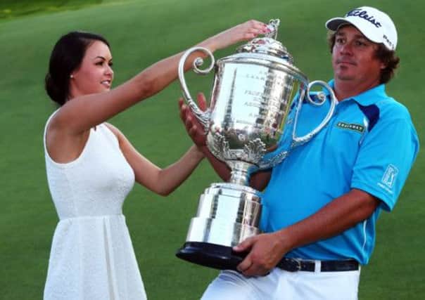 Jason Dufner appears in need of some assistance from his wife Amanda as he gets to grips with the Wanamaker Trophy. Picture: Getty