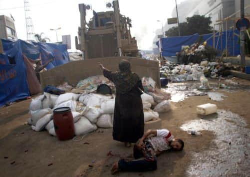 An Egyptian woman tries to stop a military bulldozer from hurting a wounded youth. Picture: AFP