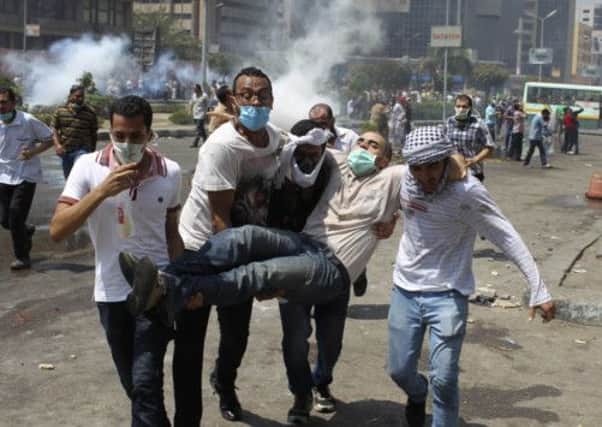 Supporters of deposed Egyptian President Mohamed Mursi carry a protester injured during clashes with riot police. Picture: Reuters