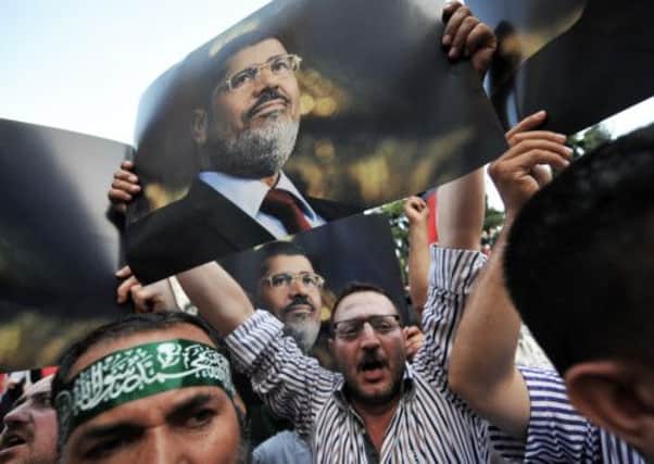 Turkish demostrators hold posters of Egypt's ousted president Mohamed Morsi during a demonstration. Picture: Getty