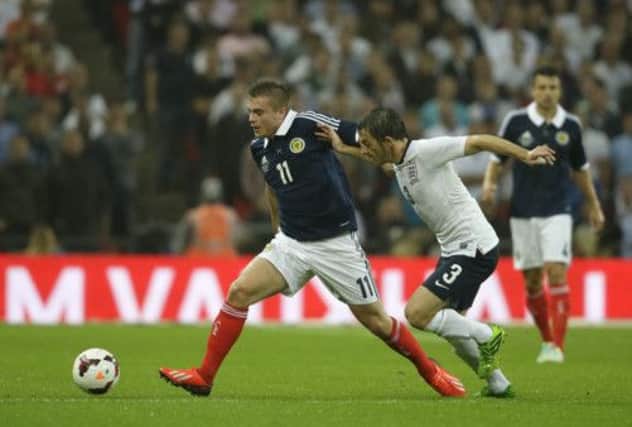 Leighton Baines, right, attempts to get the ball from Scotland's James Forrest. Picture: AP