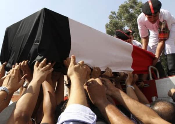 People reach for a coffin during a funeral for policemen killed during Wednesday's clashes in Cairo. Picture: Reuters