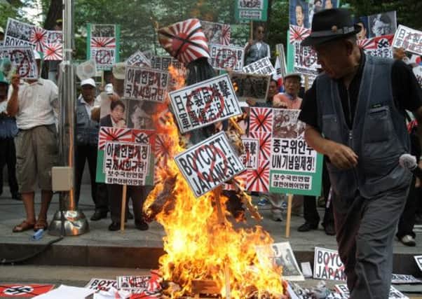 South Korean protesters burned an effigy of Japanese prime minister Shinzo Abe outside the embassy in Seoul after his ministers visited the war shrine. Picture: Getty