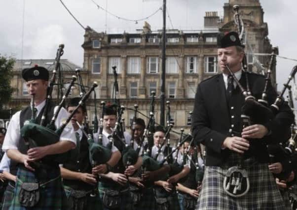 Pipe bands march through Glasgow ahead of the World Pipe Band Championships yesterday. Picture: PA