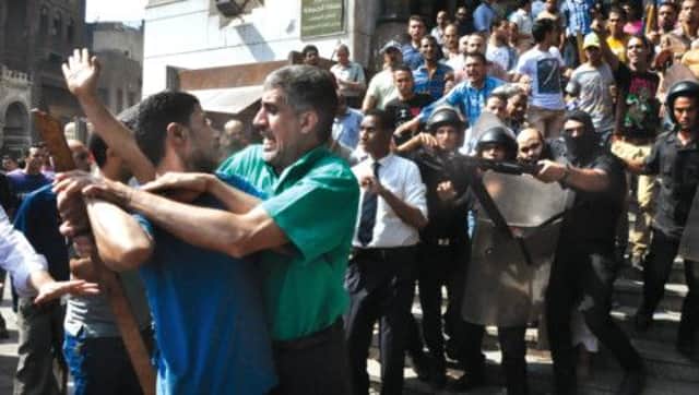 Security forces escort a Muslim Brotherhood supporter out of the mosque through angry crowds. Picture: AP