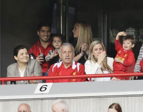 Home sweet home: Luis Suarez, who is staying at Liverpool, enjoys yesterday's game with his family. Picture: AP