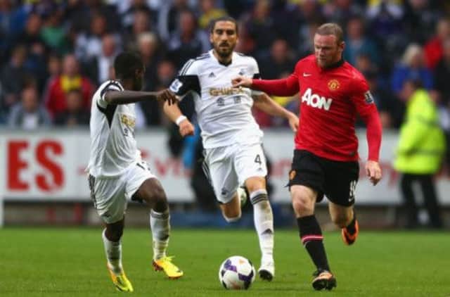 Wayne Rooney runs at Swansea's Nathan Dyer as Chico Flores looks on. Picture: Getty