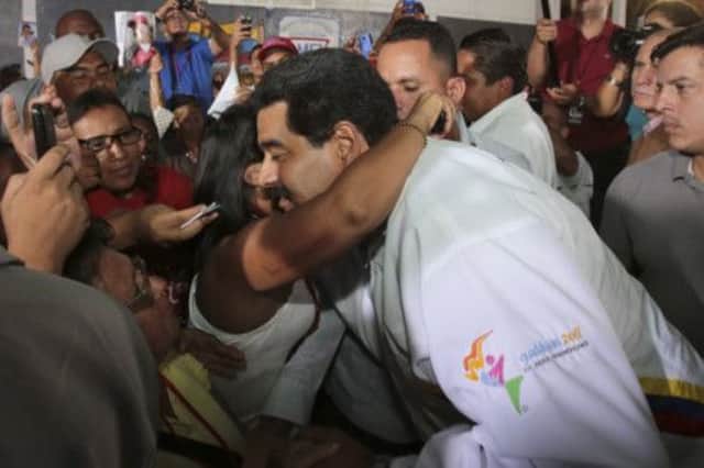 Underfire president Nicolas Maduro is greeted by supporters at a community meeting in the capital Caracas.  Picture: Reuters