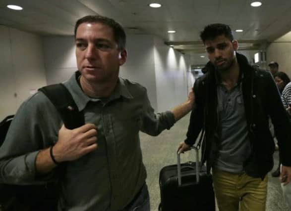 Glenn Greenwald (left) at Rio de Janeiro airport with his partner David Miranda, who was held at Heathrow for nine hours. Picture: Reuters