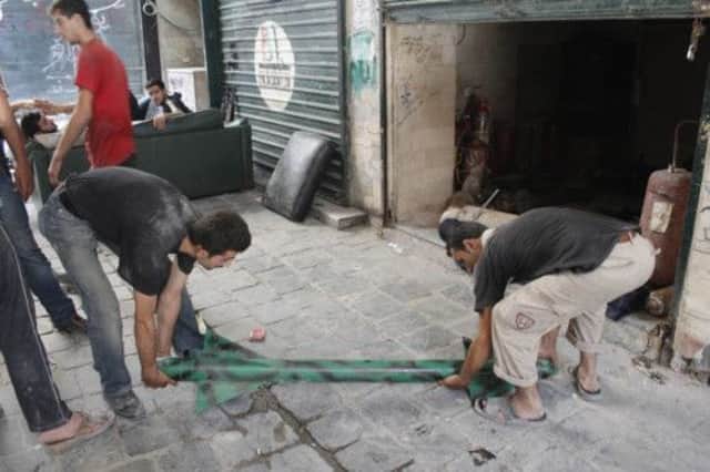 Free Syrian Army fighters handle a locally made rocket in old Aleppo. Picture: Reuters