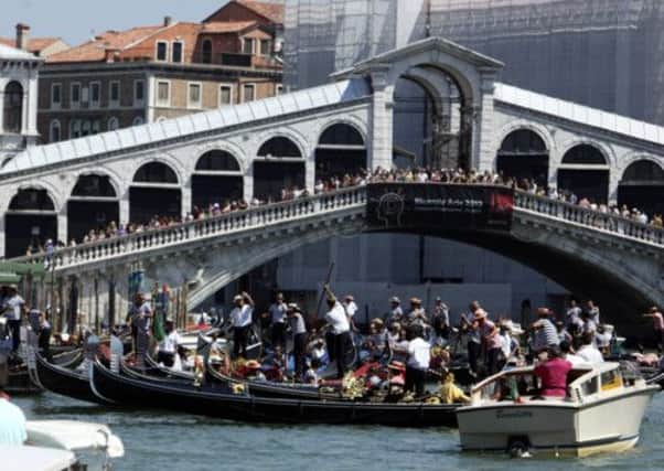 Gondoliers gather to pay their respects at the spot where a German tourist was killed in an apparent boat crash. Picture: Reuters