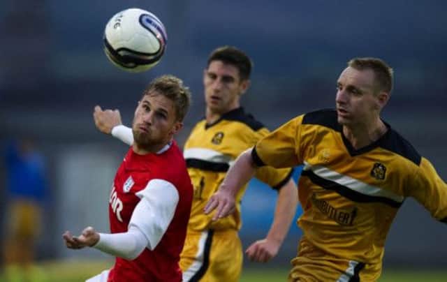David Goodwillie shields the ball from Dumbarton's Andy Graham. Picture: SNS