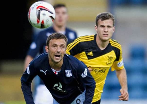 Dundee's Kevin McBride clears under pressure from Livingstons Danny Denholm last night. Picture: SNS