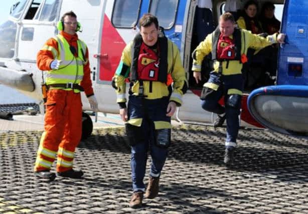 George Osborne, centre, arrives on the Montrose platform yesterday, having flown there on a Super Puma AS332L. Picture: PA