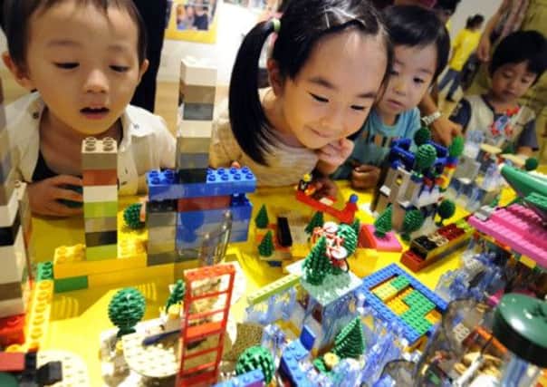 Japanese children play with LEGO bricks. The Danish block-makers are now the world's second largest toy company. Picture: Getty