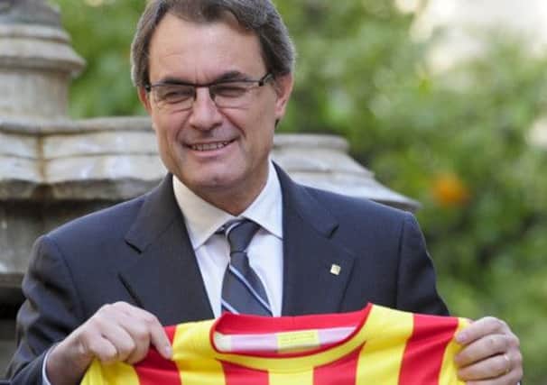 Artur Mas, President of the Catalonia regional government, holds the Barcelona away jersey which is in the style of the Catalan flag. Picture: Getty