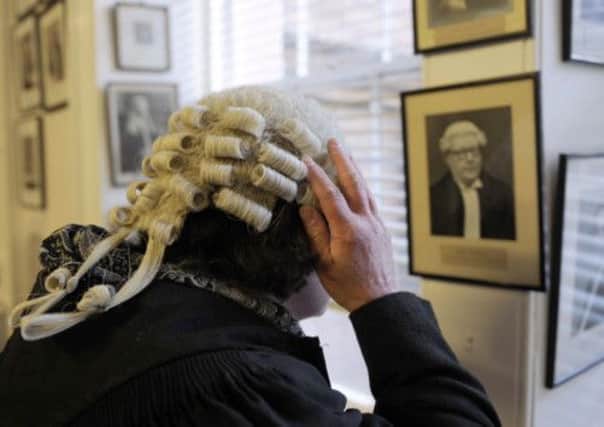An Advocate tries on her wig before going to court.  Picture: Ian Rutherford