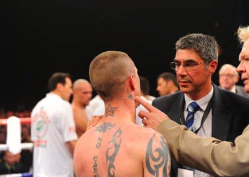 Ricky Burns is inspected by ringside doctors - his jaw was broken early in the fight. Picture: Robert Perry