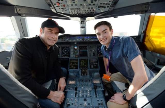 John Travolta sits in the cockpit of a Qantas Airbus A380 with Tom Hall 18, from Perth, Scotland. Picture: PA
