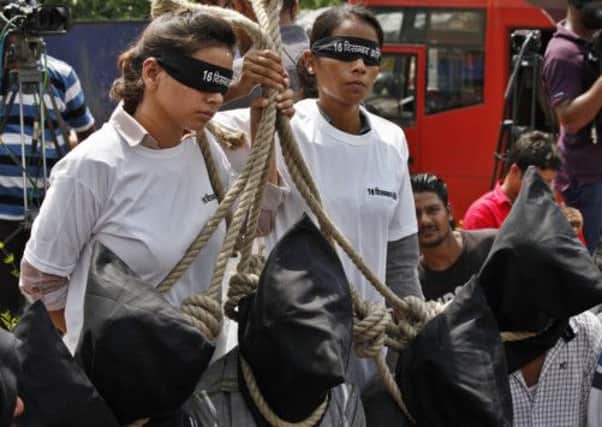 Protestors stage a mock hanging scene outside a court in demands for rapists to be given the death penalty. Picture: Getty