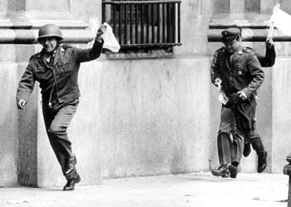 Police officers assigned to guard the presidential palace in Santiago surrender during the military coup led by Gen. Pinochet in 1973. Picture: AP