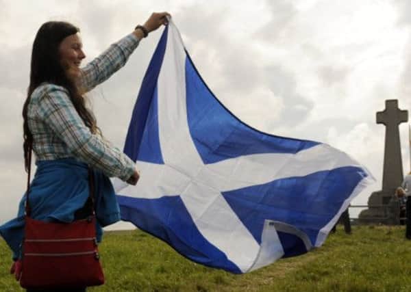 A woman holds a saltire at Flodden Field. Picture: Phil Wilkinson