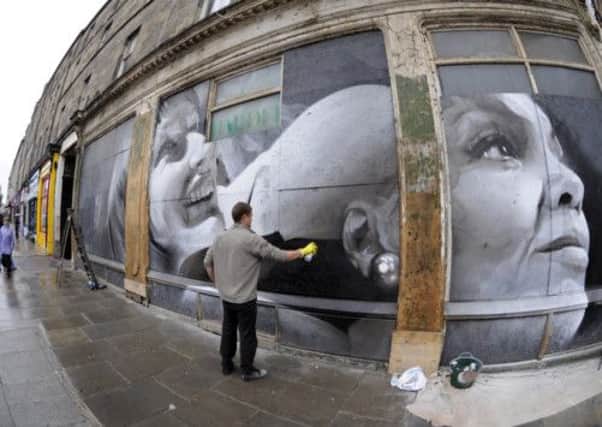 Guido van Helten puts the finishing touches on his Leith Walk mural. Picture: Greg Macvean