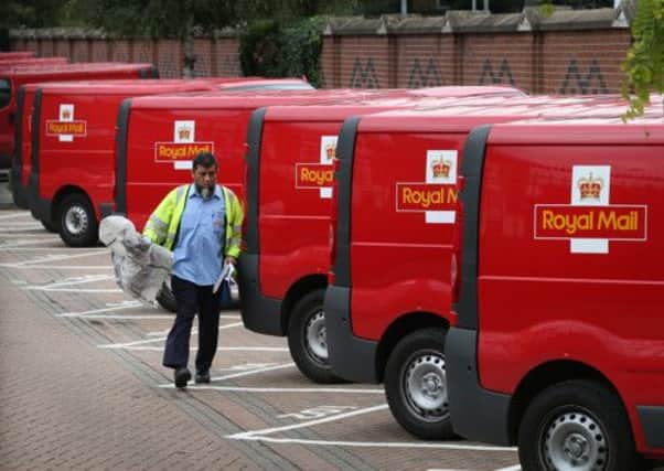 A Royal Mail worker walks past a row of vans in London. Picture: Getty