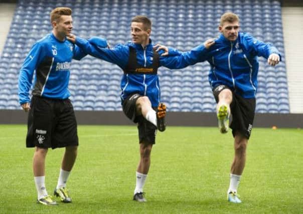 Rangers trio Lewis MacLeod, Ian Black and Kyle Hutton limber up at training. Picture: SNS
