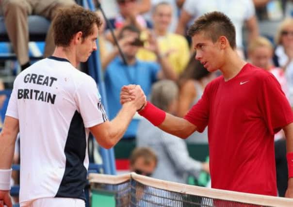 Andy Murray is congratulated on his win by Borna Coric yesterday  but the Scot struggled with back pain during the match. Picture: Getty