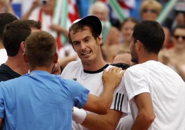 Andy Murray, centre, with his team mates, celebrates victory over Ivan Dodig. Picture: AP