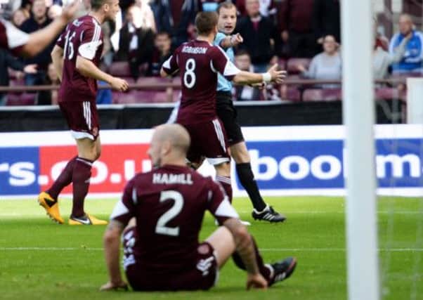 Referee Willie Collum points to the spot as Jamie Hamill sits on the ground in disbelief. Picture: SNS