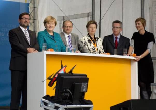 Angela Merkel and colleagues look bemused as a drone - launched by a photojournalist - crashes onto the stage at an event. Picture: AFP