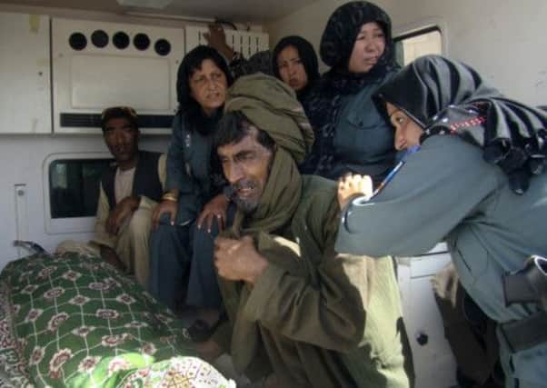 Afghan policewomen and relatives grieve over the body of the top policewoman, Negar. Picture: AP