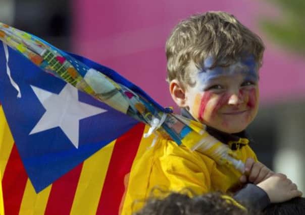 A boy holds an Independentist Catala flag (Senyera) as Catalans gather on their national day on Sept. 11. Picture: AFP