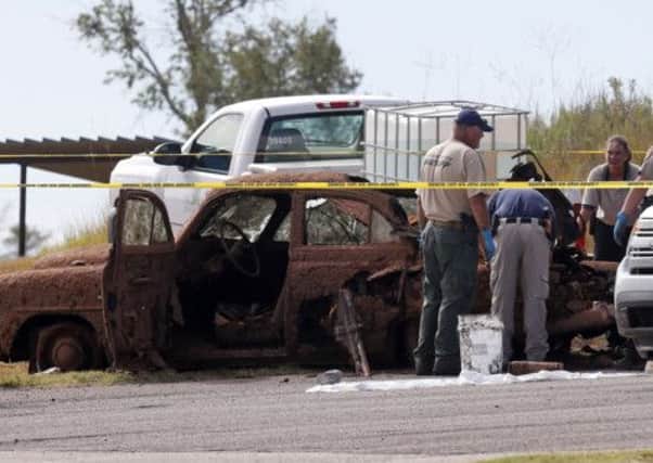 Law enforcement officials examine the two cars pulled from Foss Lake, in Foss, Oklahoma. Picture: AP