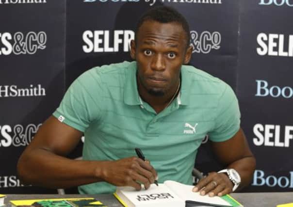 Usain Bolt was happy to pose for the media as he signed copies of his autobiography. Picture: AP